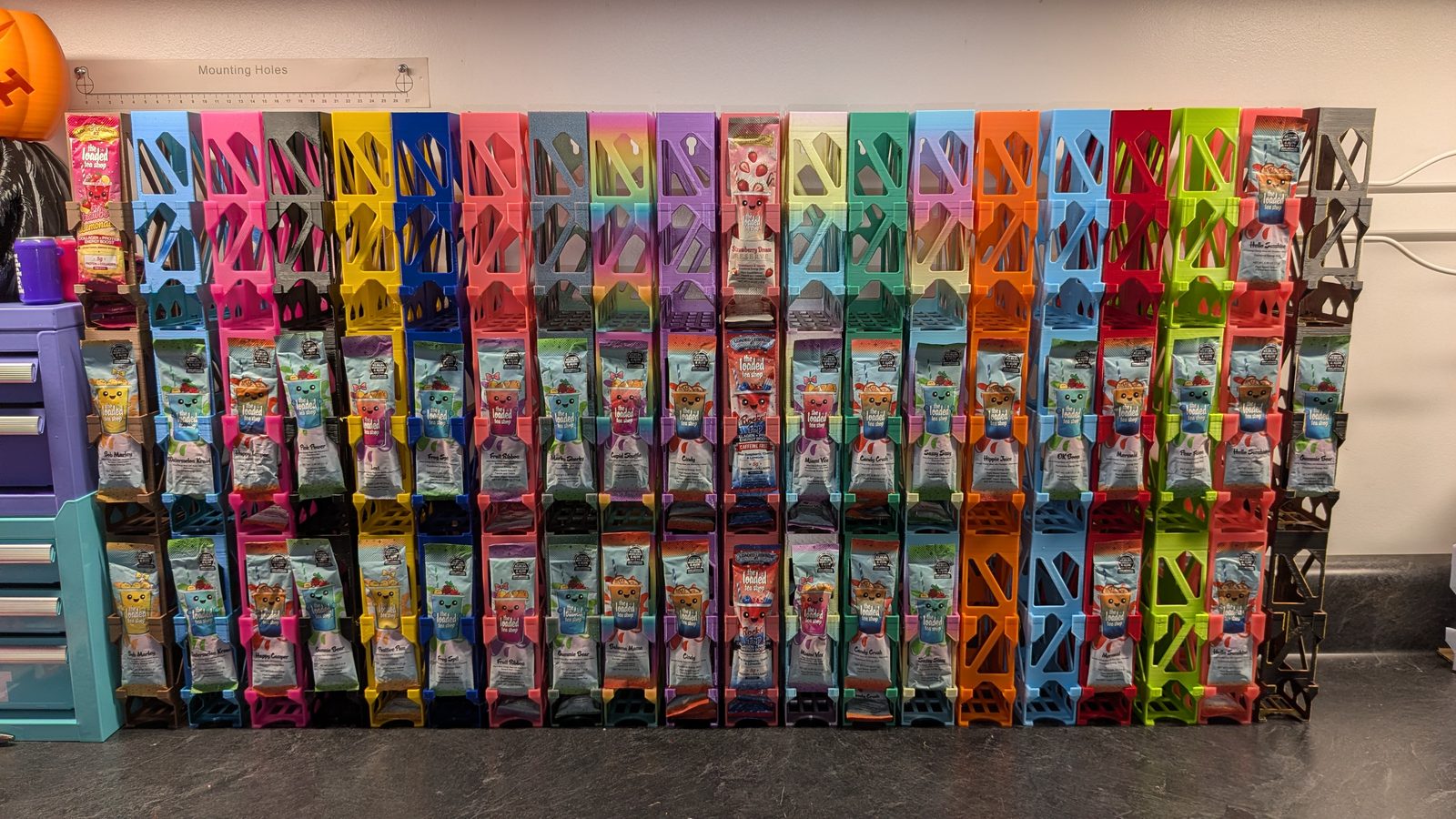 A wide group of loaded tea packet holders stacked and linked side by side in many colors